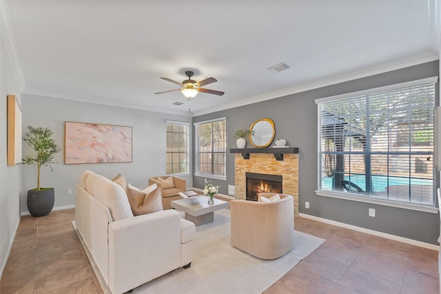 living area featuring visible vents, ornamental molding, a ceiling fan, a fireplace, and baseboards