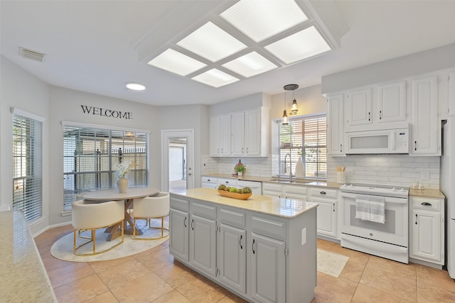 kitchen with white appliances, visible vents, light countertops, white cabinetry, and tasteful backsplash