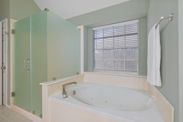 bathroom with a jetted tub and a stall shower