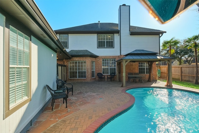 view of swimming pool with a gazebo, a fenced in pool, a patio, and fence