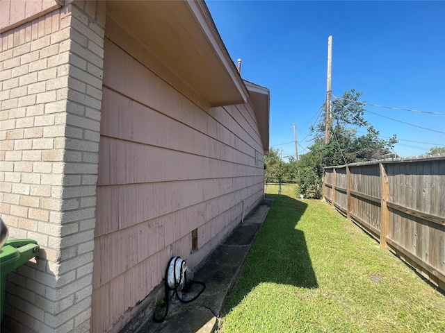 view of home's exterior featuring a lawn and fence