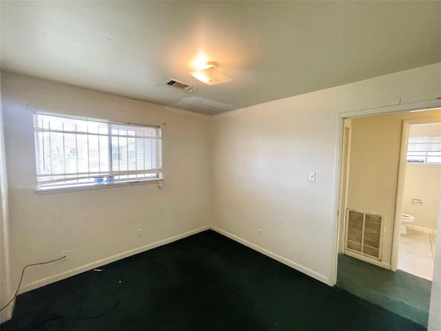 empty room featuring baseboards and visible vents