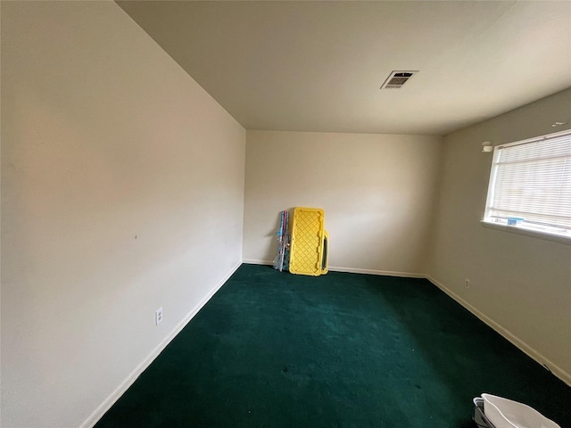 carpeted spare room featuring baseboards and visible vents