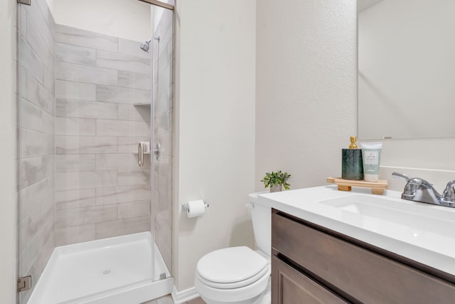 bathroom with a stall shower, toilet, and vanity