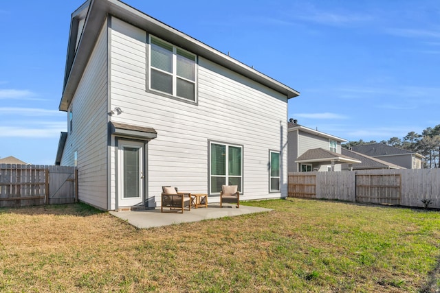 back of property with a patio area, a fenced backyard, and a yard