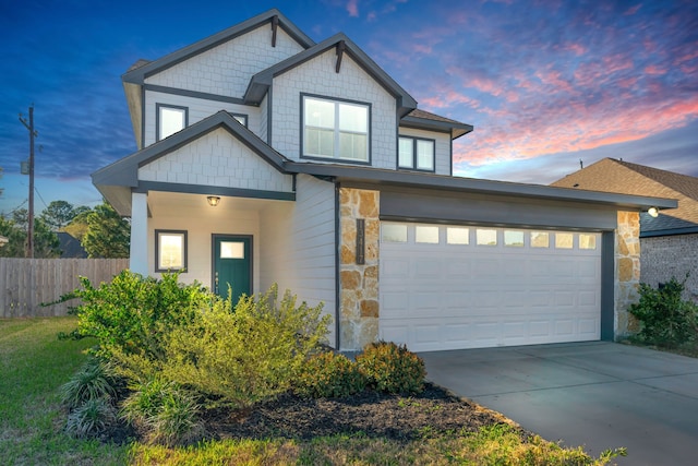 craftsman inspired home featuring concrete driveway, a garage, fence, and stone siding