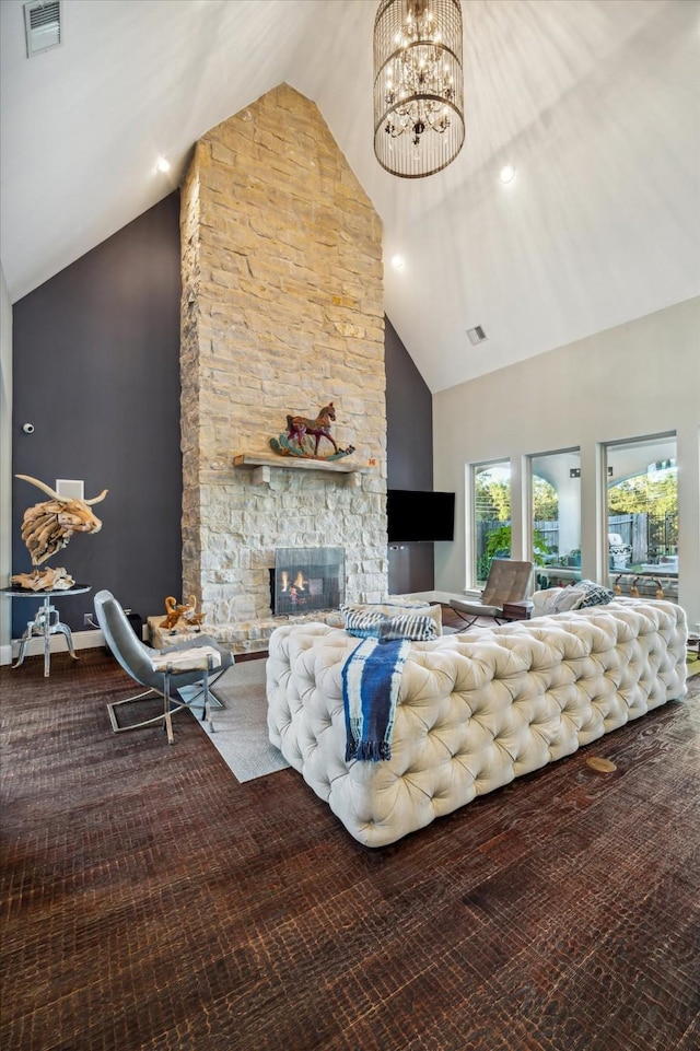 living area featuring visible vents, baseboards, a fireplace, a notable chandelier, and high vaulted ceiling