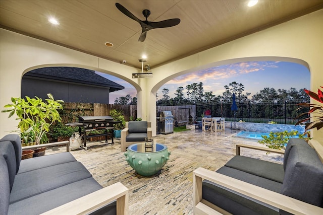 patio terrace at dusk with outdoor dining space, area for grilling, and an outdoor hangout area