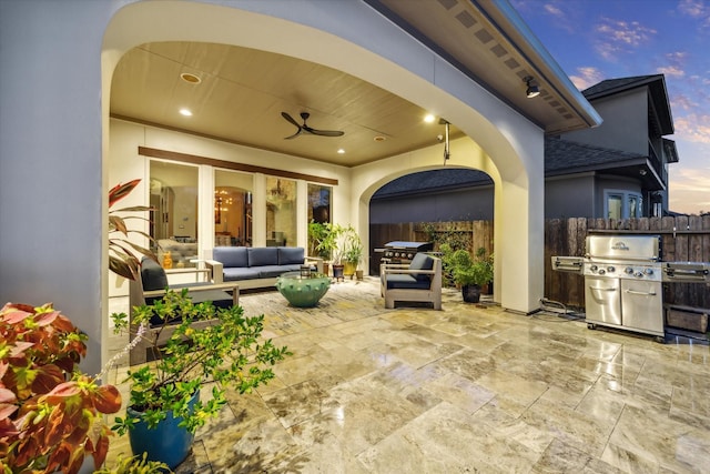 patio terrace at dusk with a ceiling fan, a grill, outdoor lounge area, and fence