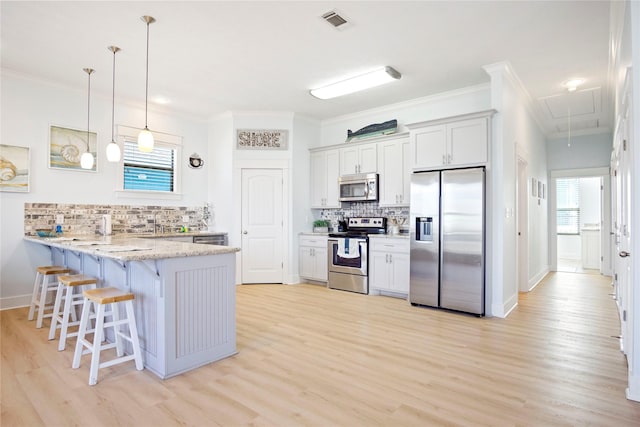 kitchen with stainless steel appliances, a peninsula, a breakfast bar area, crown molding, and light stone countertops