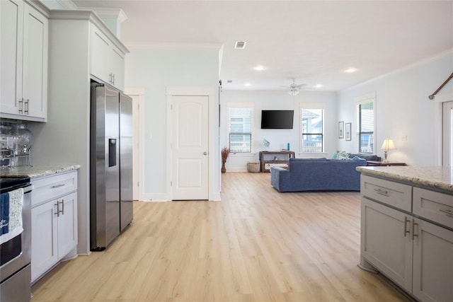 kitchen with light wood-type flooring, visible vents, appliances with stainless steel finishes, and ornamental molding