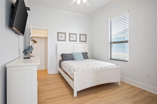 bedroom featuring light wood-style flooring, baseboards, ornamental molding, and a ceiling fan