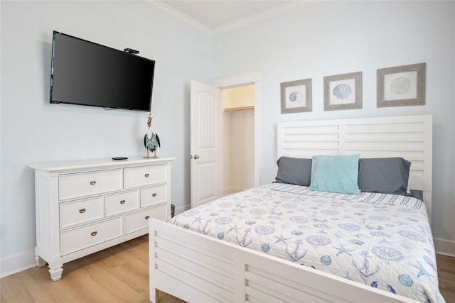 bedroom featuring light wood-style flooring, crown molding, and baseboards