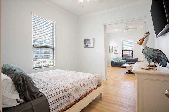 bedroom featuring crown molding, a ceiling fan, light wood-type flooring, and baseboards