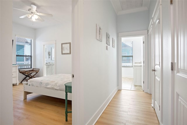 corridor featuring visible vents, baseboards, and light wood-style floors