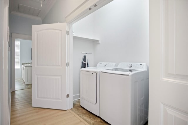 laundry area with visible vents, crown molding, light wood-type flooring, laundry area, and washer and dryer