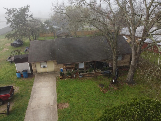 view of front of house with cooling unit, a front lawn, and roof with shingles