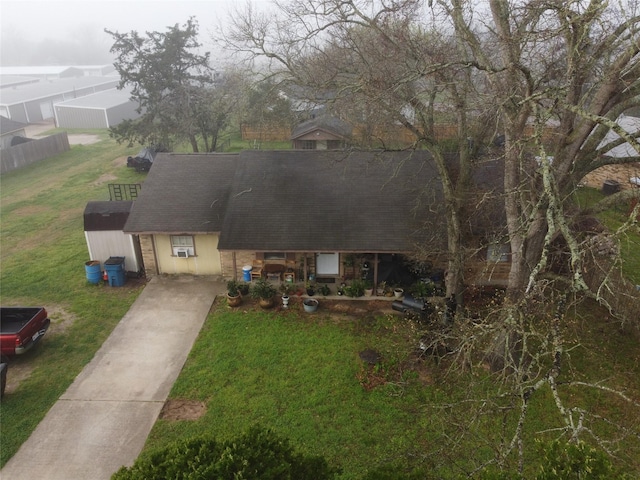 view of front of property featuring a shingled roof and a front yard