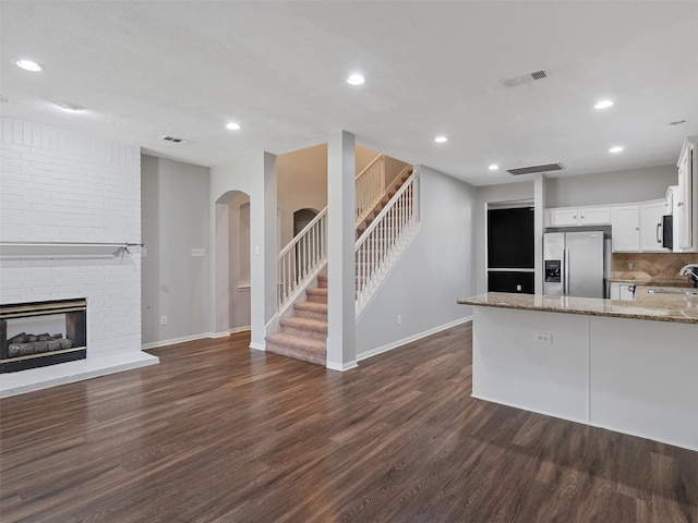 23134 Beech Canyon Dr, Katy, TX 77494 - kitchen with stainless steel fridge, a sink, light stone countertops, dark wood-style floors, and recessed lighting