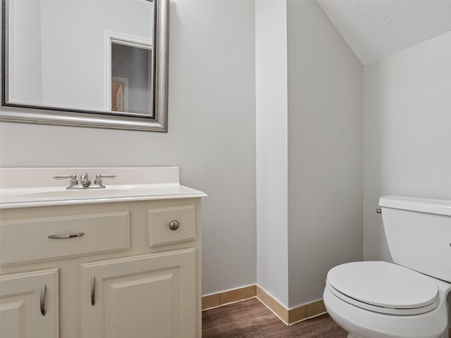 23134 Beech Canyon Dr, Katy, TX 77494 - bathroom featuring lofted ceiling, wood finished floors, toilet, vanity, and baseboards