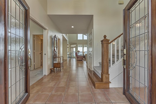 foyer with light tile patterned floors and stairs