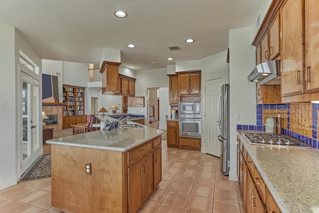 84 Waterford Way, Montgomery, TX 77356 - kitchen featuring stainless steel appliances, exhaust hood, a sink, backsplash, and light stone counters