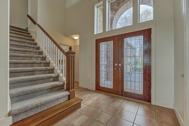 84 Waterford Way, Montgomery, TX 77356 - entryway featuring stairway, a towering ceiling, tile patterned flooring, baseboards, and french doors