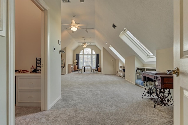 additional living space with lofted ceiling with skylight, carpet flooring, visible vents, and a textured ceiling