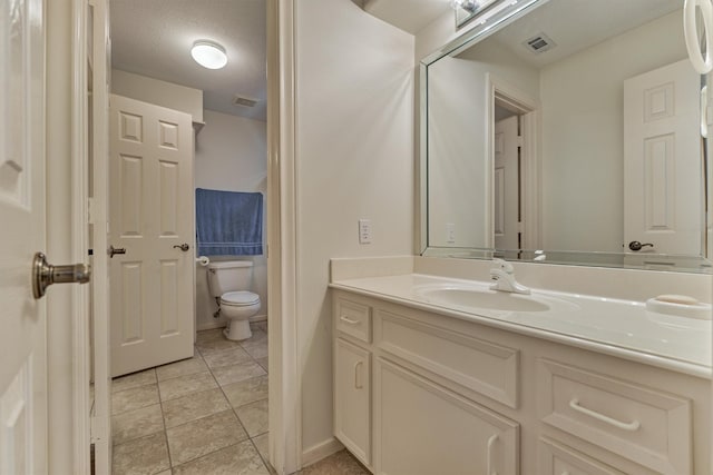 bathroom featuring tile patterned floors, visible vents, toilet, and vanity