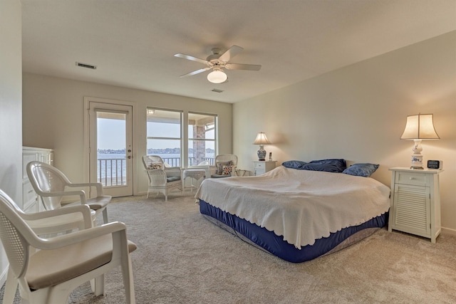 bedroom featuring visible vents, light colored carpet, ceiling fan, and access to outside