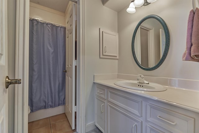 full bath with a shower with curtain, vanity, and tile patterned flooring