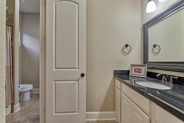 full bathroom with toilet, vanity, and baseboards