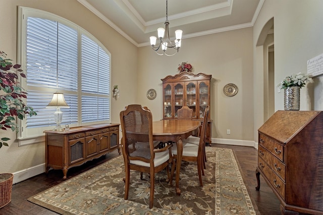 dining area featuring a notable chandelier, ornamental molding, a tray ceiling, dark wood-style floors, and baseboards