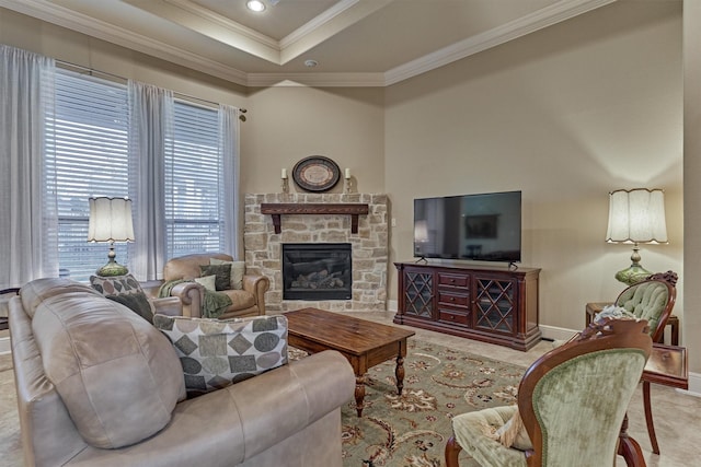 living area featuring baseboards, ornamental molding, a stone fireplace, recessed lighting, and a raised ceiling