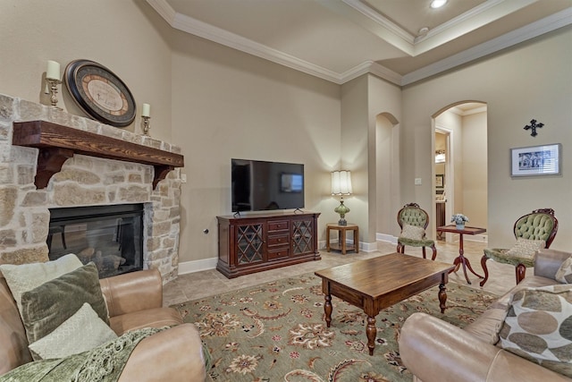 tiled living room with arched walkways, a fireplace, crown molding, and baseboards