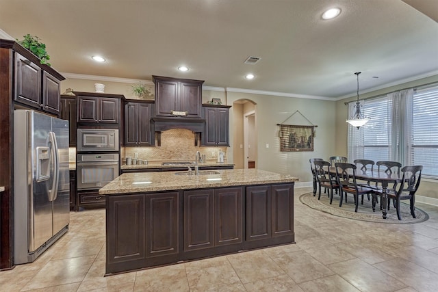 kitchen featuring arched walkways, a sink, stainless steel appliances, dark brown cabinets, and backsplash