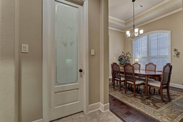 dining area with visible vents, ornamental molding, a tray ceiling, baseboards, and a chandelier