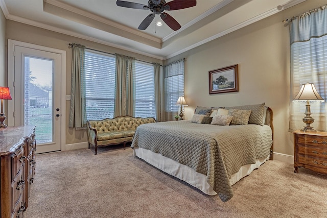 carpeted bedroom featuring a raised ceiling, multiple windows, access to exterior, and ornamental molding