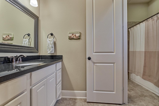 full bath featuring vanity and baseboards