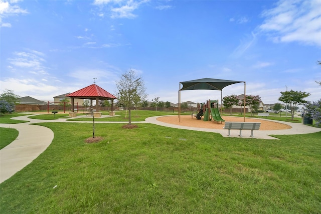 communal playground with a gazebo, a yard, and fence