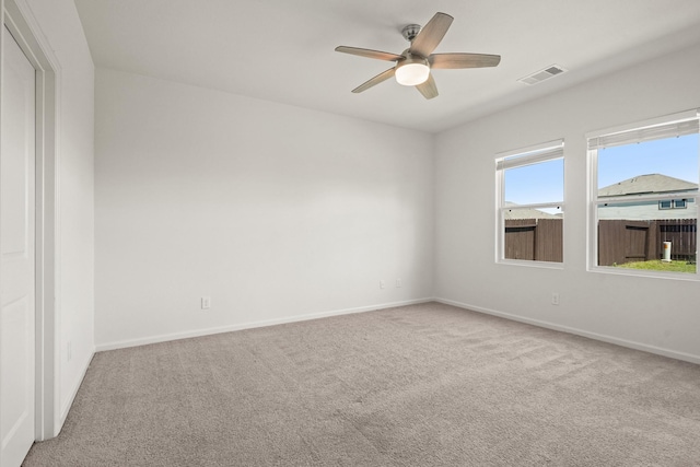 empty room with visible vents, carpet flooring, baseboards, and ceiling fan