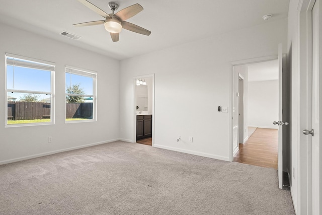 unfurnished bedroom featuring visible vents, a ceiling fan, ensuite bath, carpet flooring, and baseboards