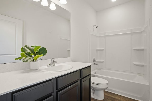 full bath with shower / bath combination, toilet, vanity, and wood finished floors