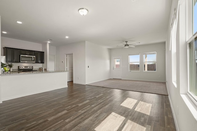 unfurnished living room with dark wood finished floors, recessed lighting, and baseboards