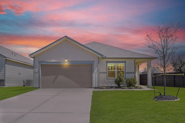 ranch-style house with fence, central AC unit, driveway, a yard, and an attached garage