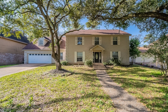 colonial home with a garage, a front lawn, brick siding, and driveway