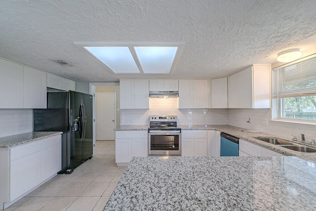 kitchen featuring dishwashing machine, visible vents, stainless steel range with electric cooktop, under cabinet range hood, and black fridge