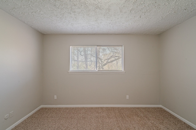 spare room with baseboards, a textured ceiling, and carpet flooring