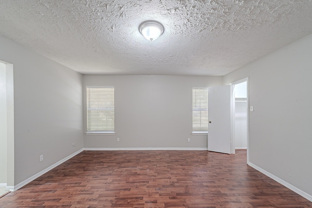 empty room featuring plenty of natural light, baseboards, and wood finished floors