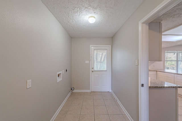 clothes washing area featuring electric dryer hookup, light tile patterned flooring, baseboards, hookup for a washing machine, and laundry area